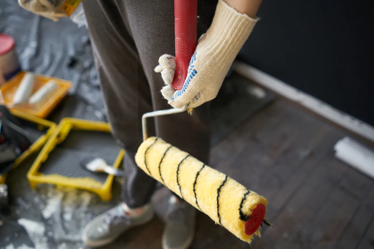 Painter rolling an even coat of paint on an interior wall