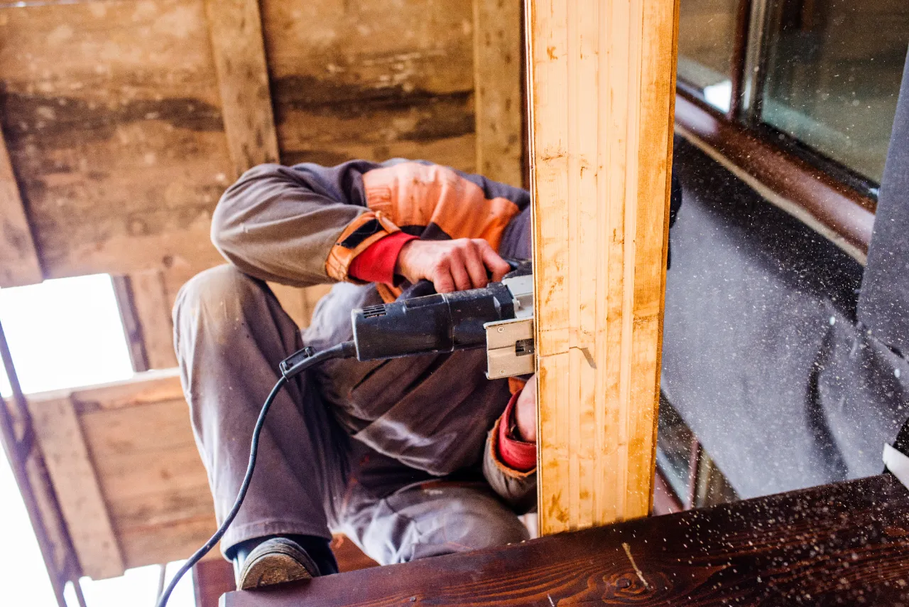 Carpenter cutting wood trim with a power saw