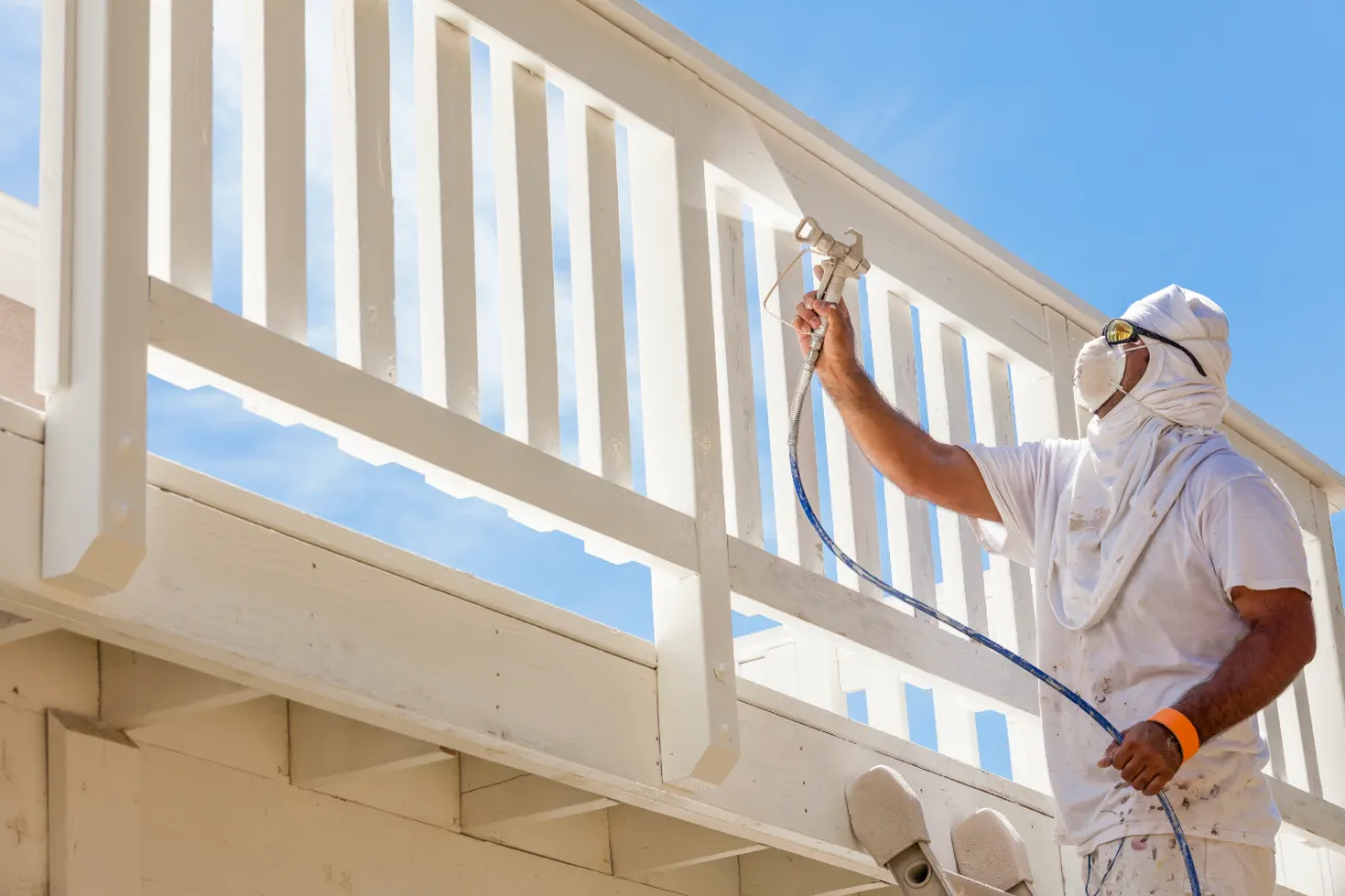 Painter finishing an outdoor wooden railing